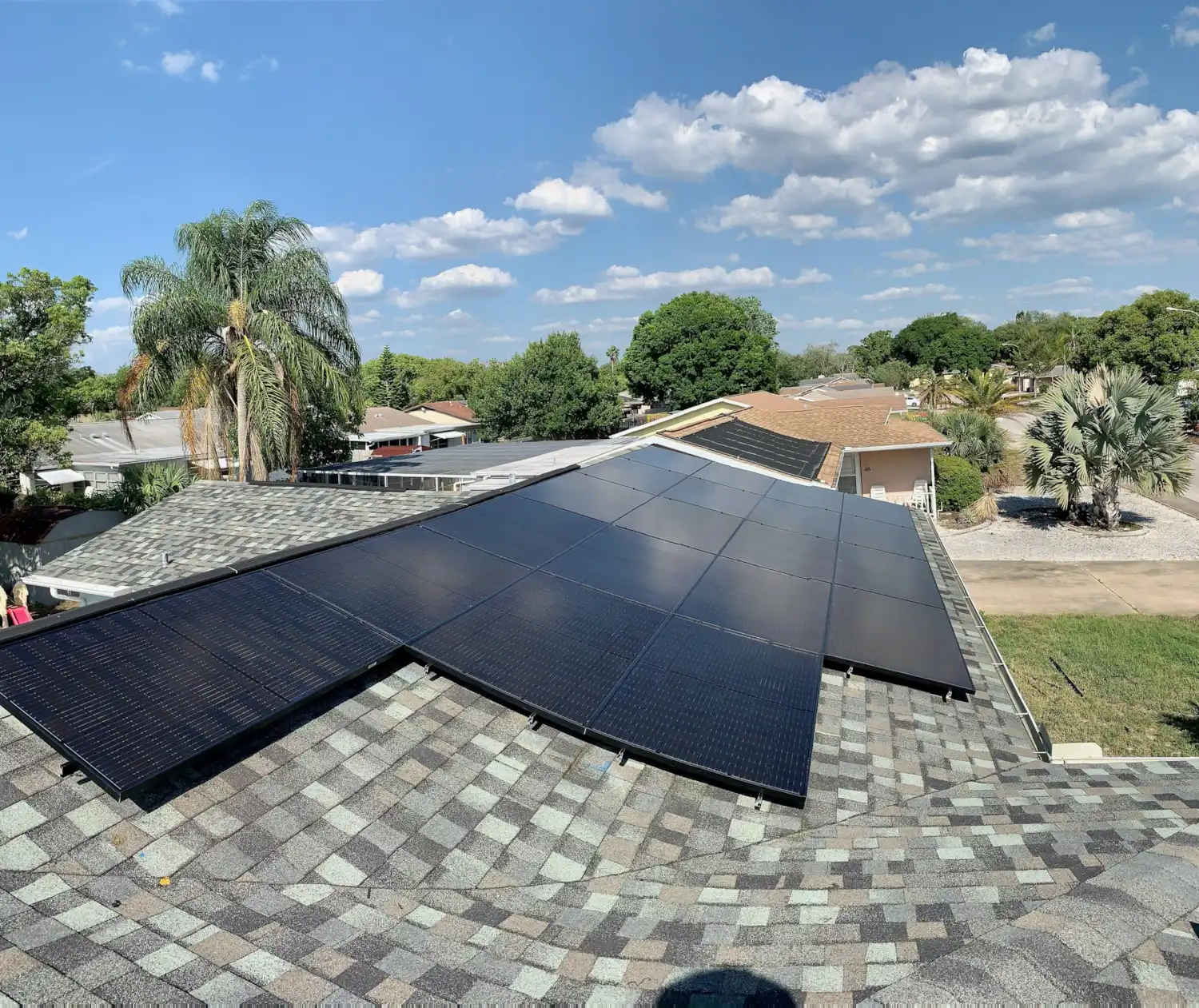 Lunex Power solar installation on shingle roof in Florida with palm trees in the background