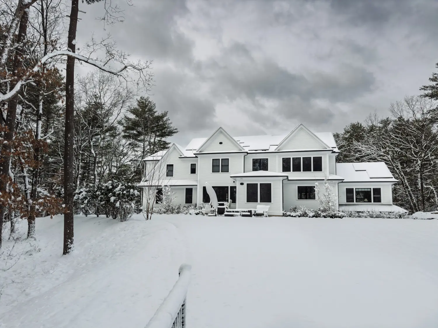 A New England home with snow covered solar solar panels on the roof